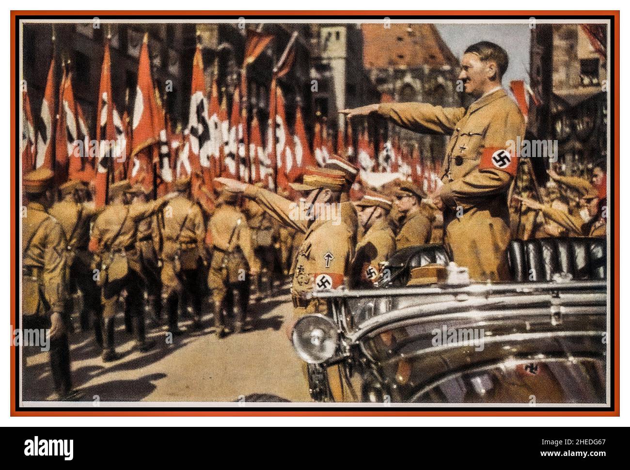 Sturmabteilung Adolf Hitler Saluting SA Trupps Vintage Nazi Deutschland c1935. Nürnberger Kundgebung, farbige Fotokarte von Adolf Hitler mit Hakenkreuzarmband in offenem Mercedes und SA-Truppen, die mit Hakenkreuzfahnen vorbeimarschierten, Verlag H. Wiedemann ,Sturmabteilung die offizielle Uniform der SA war das braune Hemd mit brauner Krawatte 'The Brown Shirts'. Stockfoto