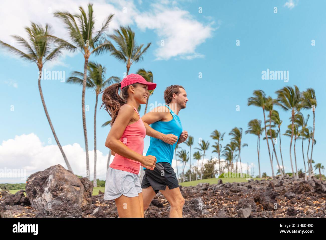 Fitness-Übungsläufer verbinden den Laufstil. Gesunde Menschen joggen gemeinsam im Sommerpark im Freien, Sportler trainieren während Hawaii Cardio Stockfoto