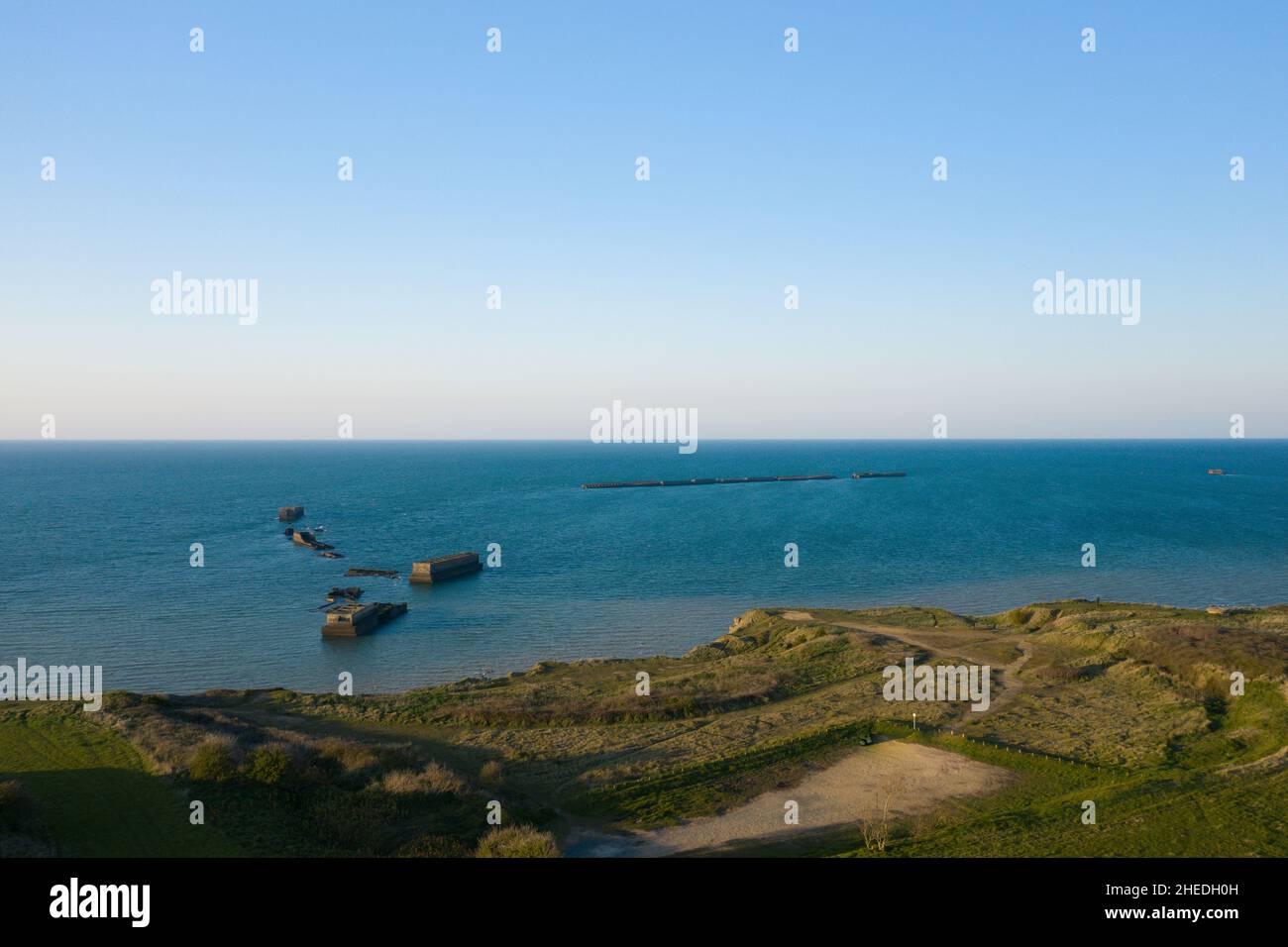 Dieses Landschaftsfoto wurde im Sommer in Europa, Frankreich und der Normandie aufgenommen. Wir können die Überreste des künstlichen Hafens von Arromanches les Bains sehen, unter t Stockfoto