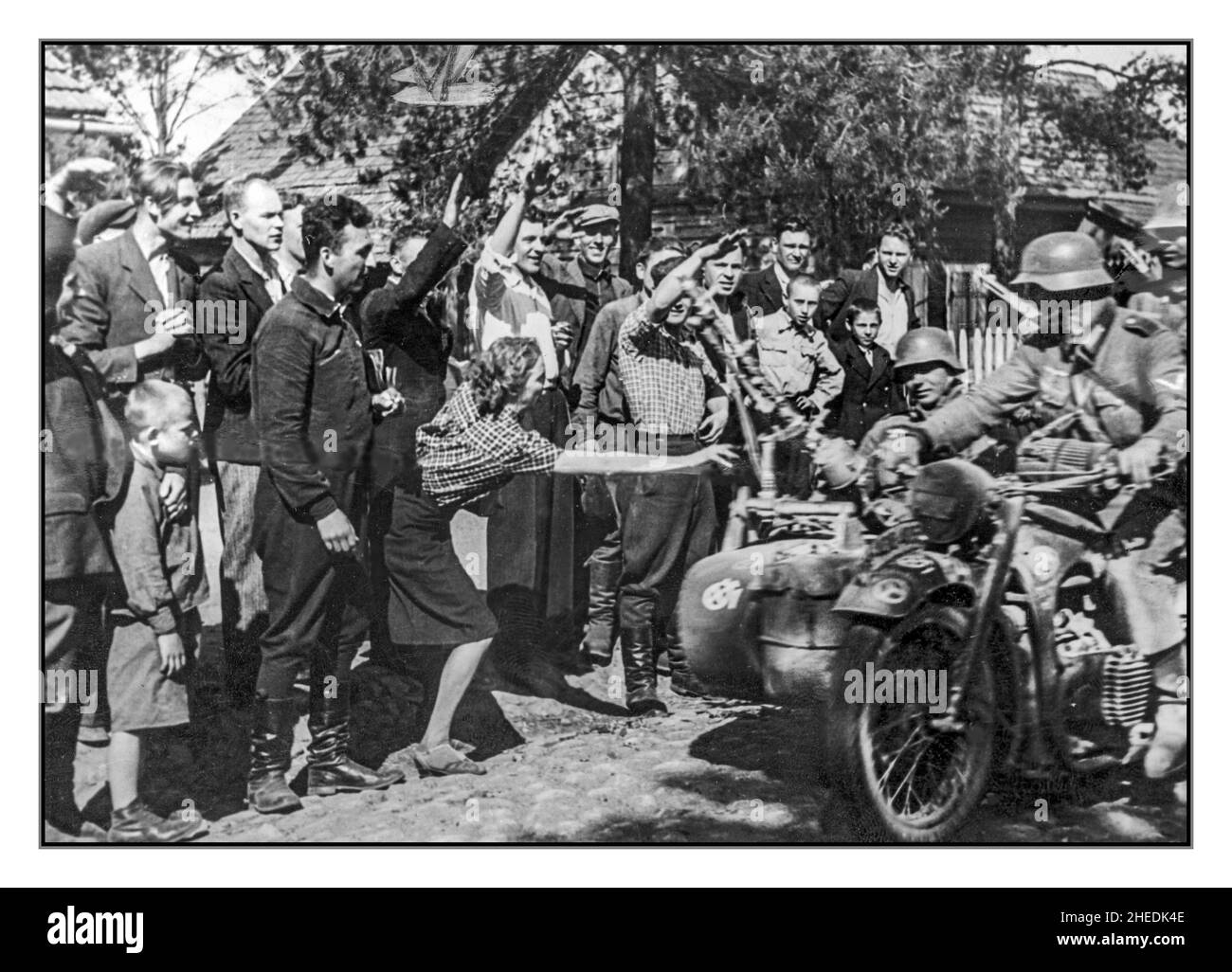 Operation Barbarossa WW2 1941 die Zivilbevölkerung an der Ostfront begrüßt (in Angst) die eindringenden deutschen Motorradfahrer der Panzerdivision 12th. Wehrmachtssoldaten auf einem BMW R75 Motorrad mit Korb. Stockfoto