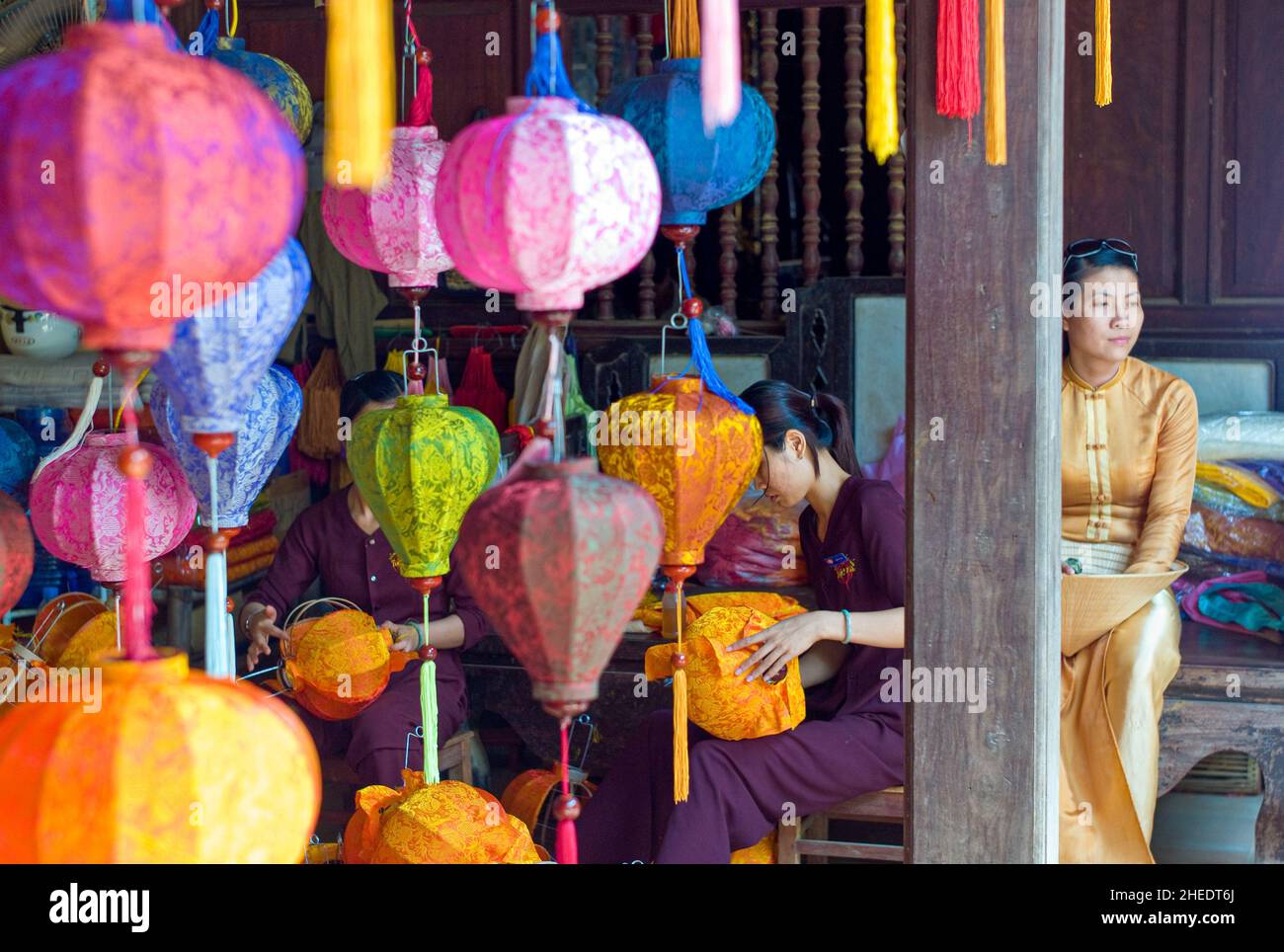 Hoi an, Vietnam - 28. Mai 2008: Eine elegante vietnamesische Dame, die in einem farbenfrohen, traditionellen Lampenladen sitzt Stockfoto