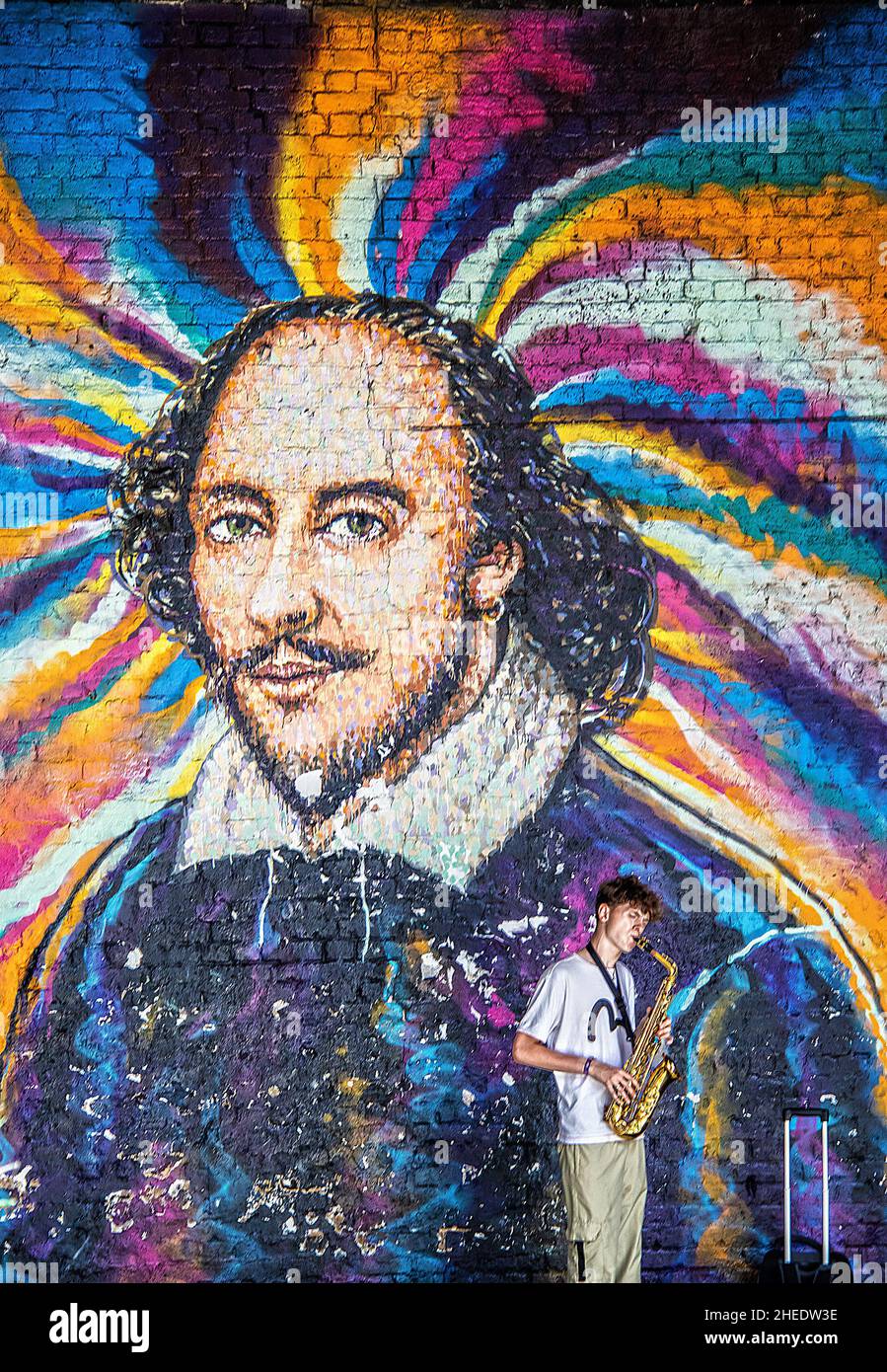 2019 07 24 London UK - Wandbild von Shakespeare in der Nähe des Globe Theatre in London mit Straßenkünstler, der Trompete spielt. Stockfoto