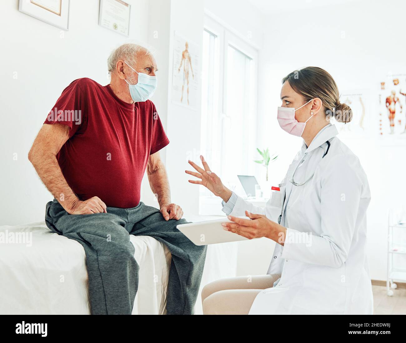 Arzt Senior Patient Frau medizinisches Krankenhaus Gesundheit Mann Medizin Büro Corona Virus Maske Klinik Gesundheitswesen Ältere reden unterstützen Tablette Stockfoto