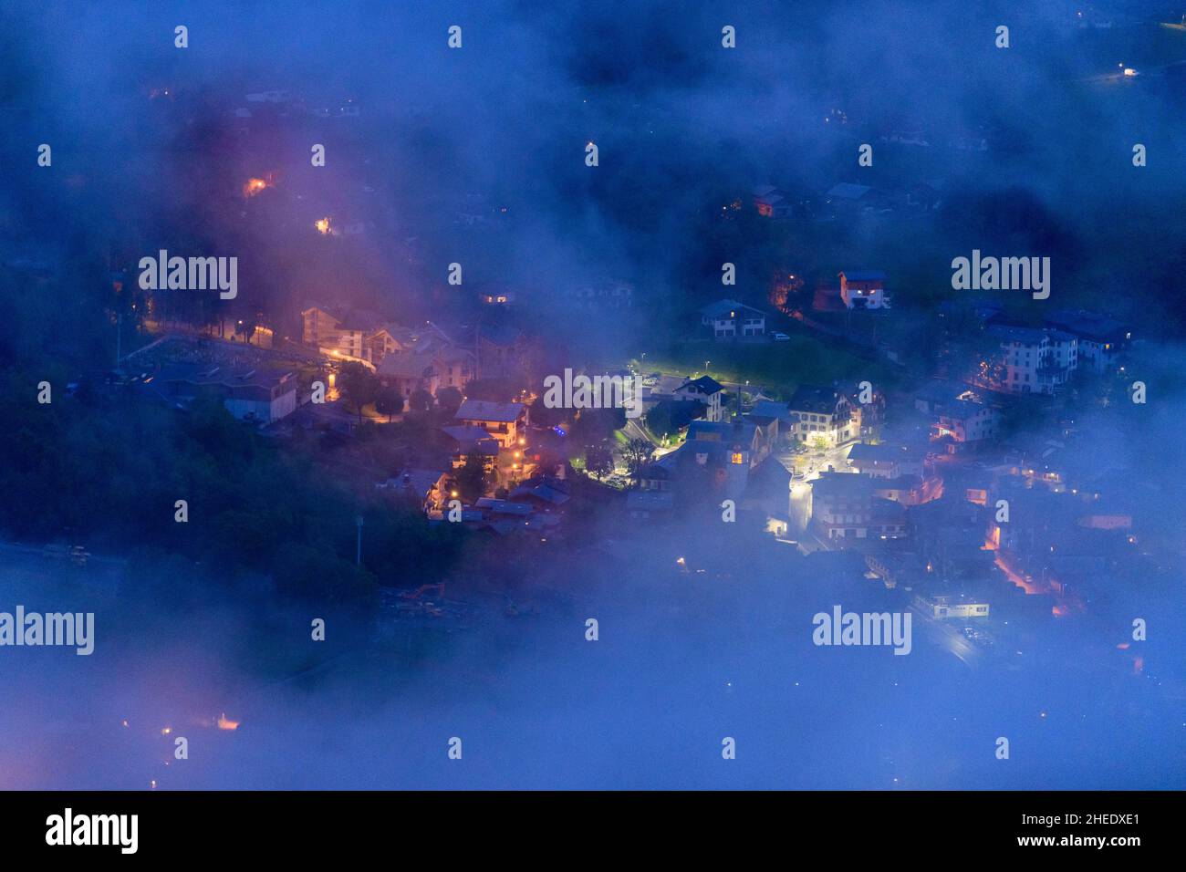 Dieses Landschaftsfoto wurde in Europa, in Frankreich, in den Alpen, in Richtung Chamonix, im Sommer aufgenommen. Wir können das Stadtzentrum von Les Houches in den Wolken sehen Stockfoto
