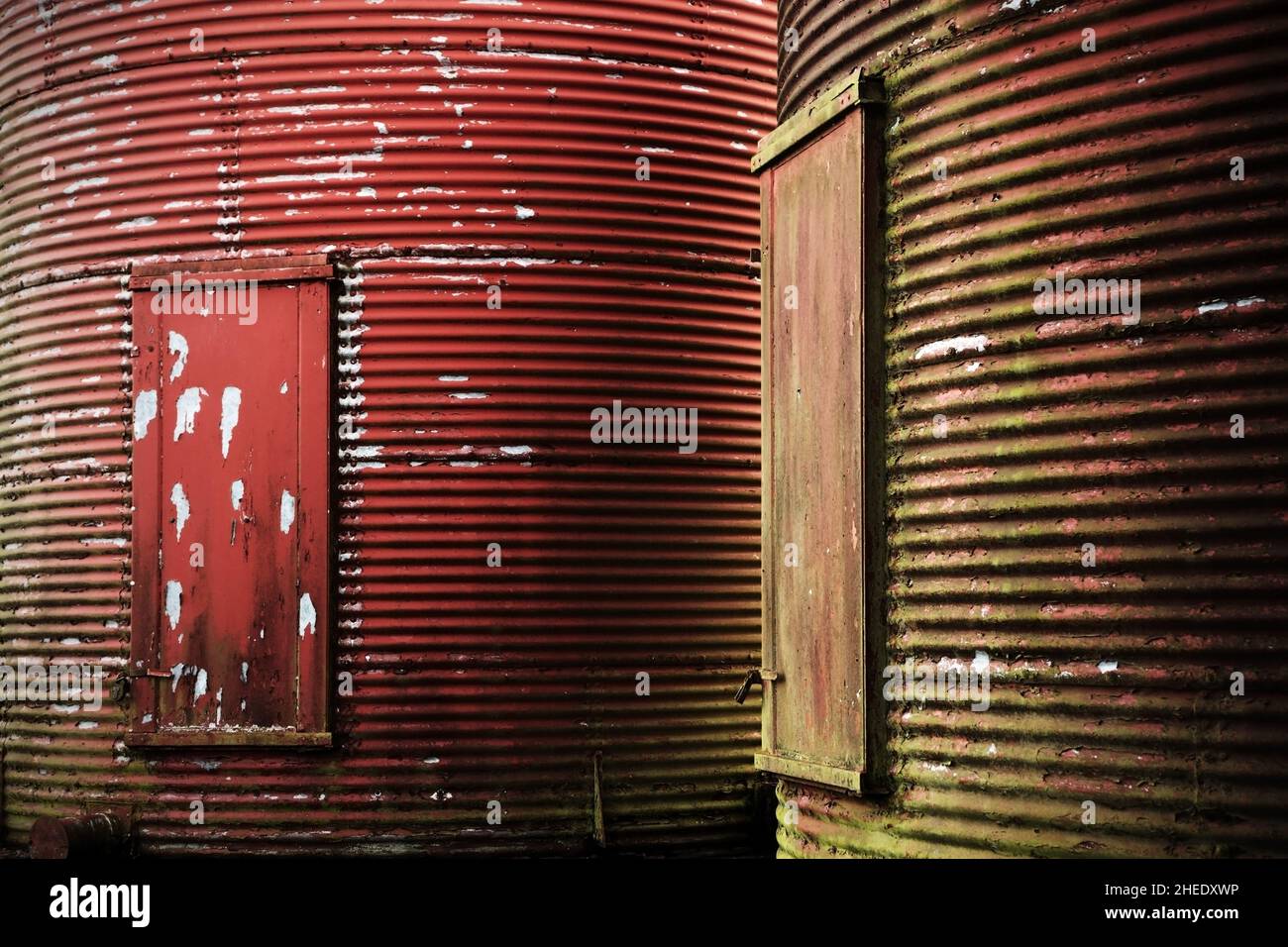 Rote Schälfarbe auf landwirtschaftlichen Silos aus Wellblech. Stockfoto