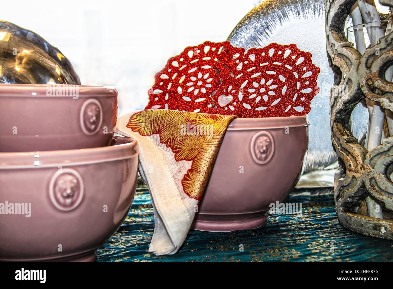 Den Tisch für ein Valentinsdinner - rosa Geschirr und Kerze mit rot glitzerndem Herz Stockfoto