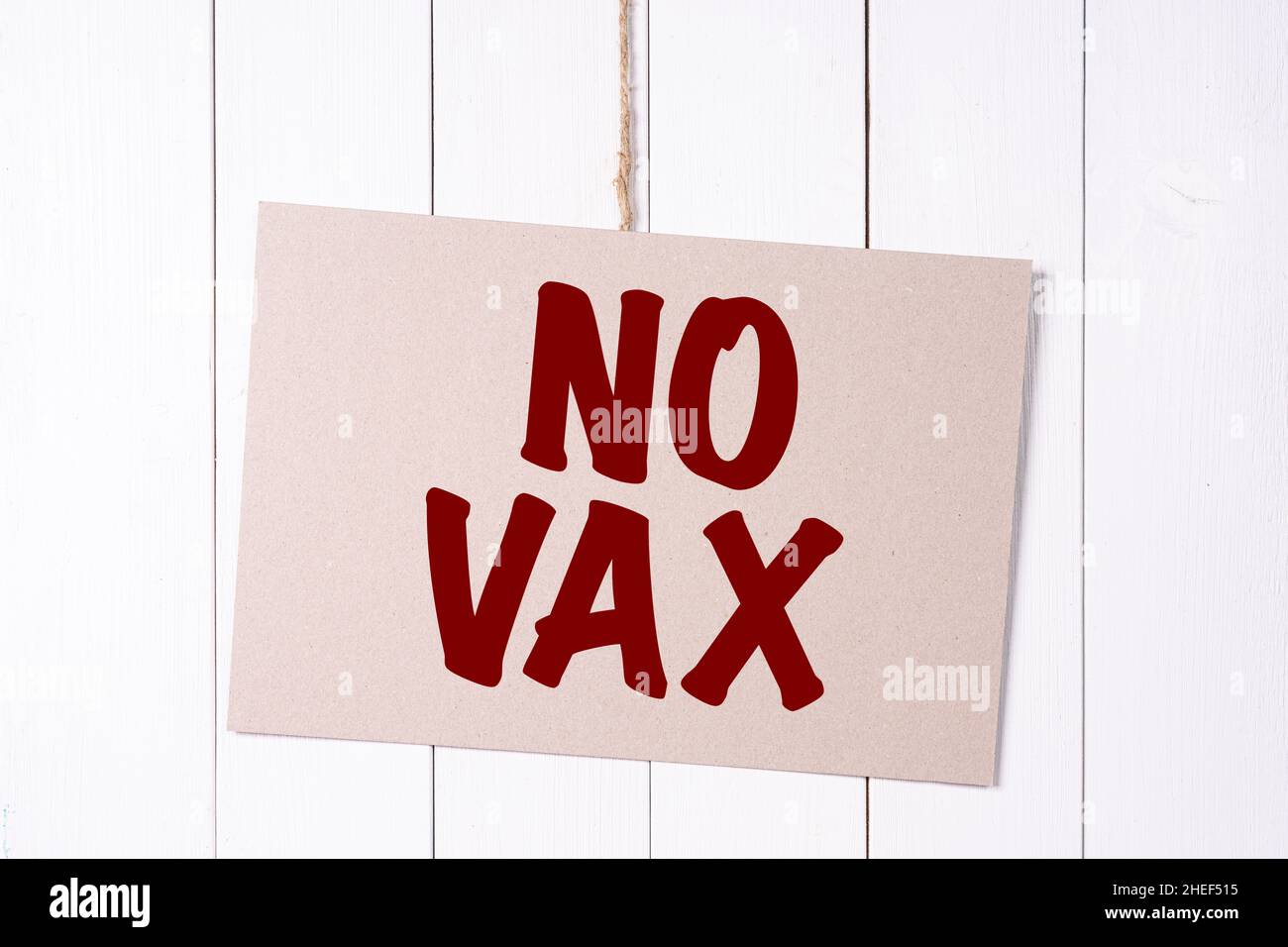 Ein Schild mit der Aufschrift No Vax hängt an einer Holzwand Stockfoto