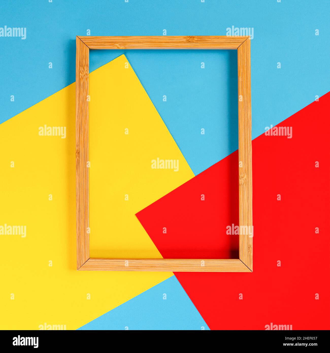 Ein Holzrahmen auf einem Hintergrund von farbigen Formen Stockfoto