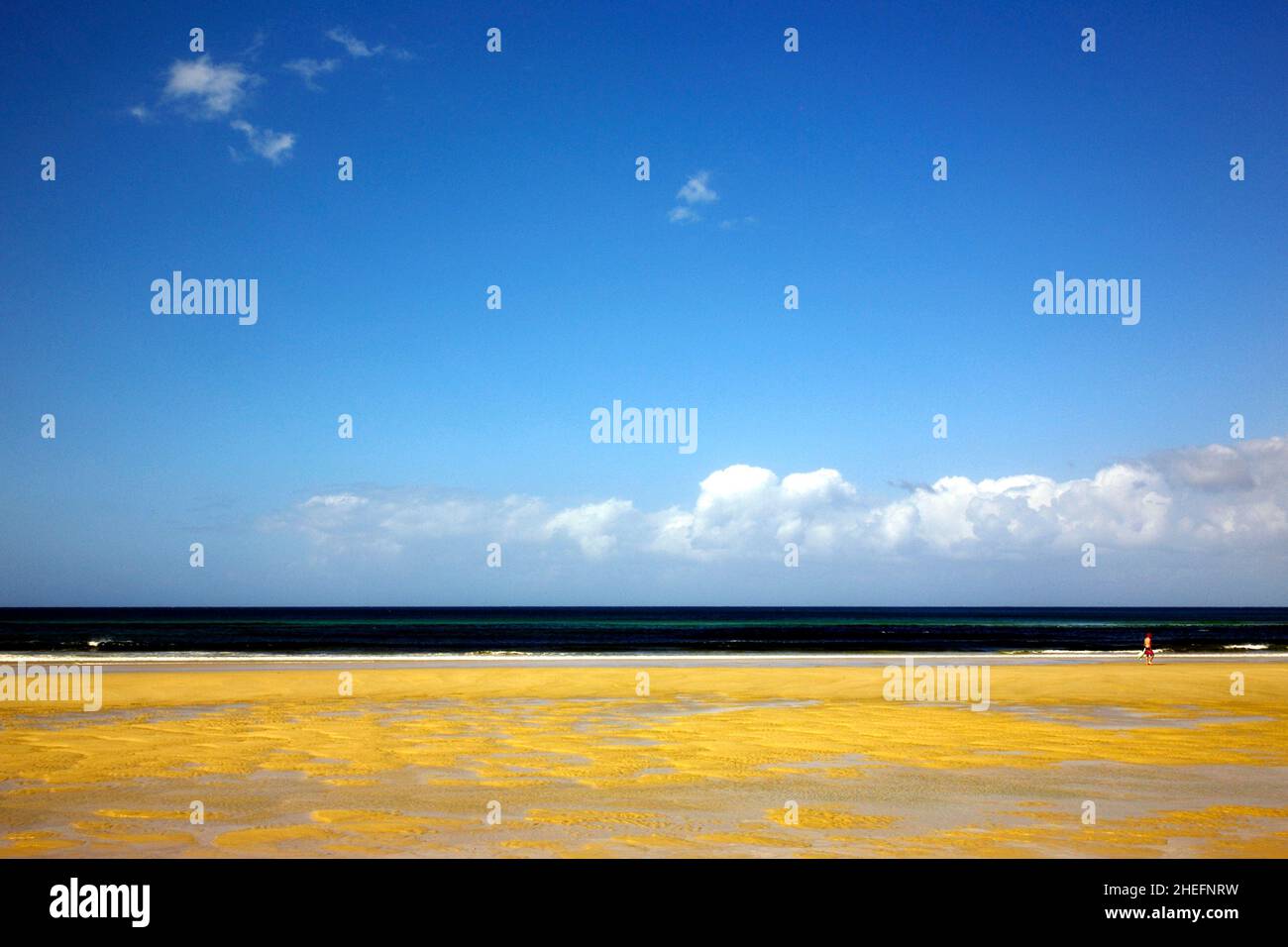 Farbfoto von Strandsand, Meeresufer und einer Person, die am Strand spaziert, Kirra Beach, Gold Coast, Queensland, Australien, 2018. Stockfoto