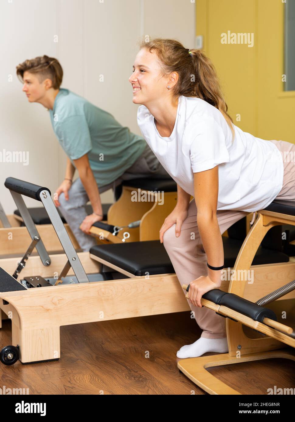 Jugendliche tun Übungen auf Pilates Reformer Stockfoto