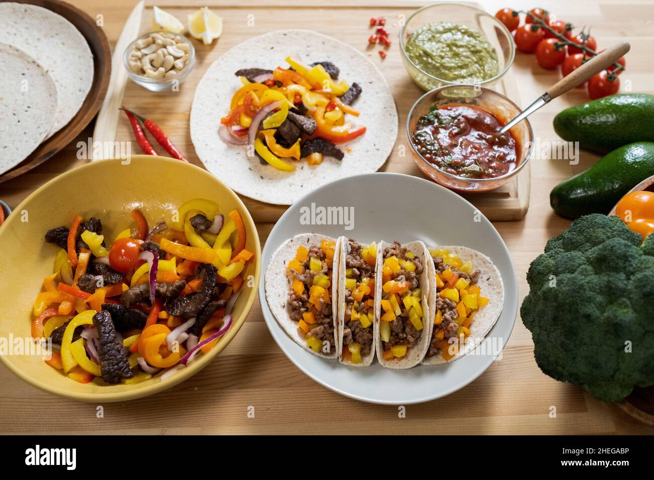 Teil der servierten festlichen Tisch mit traditionellen mexikanischen Speisen wie Taco, herzhaften und würzigen Gemüseeintopf und hausgemachten Saucen in Schüsseln Stockfoto