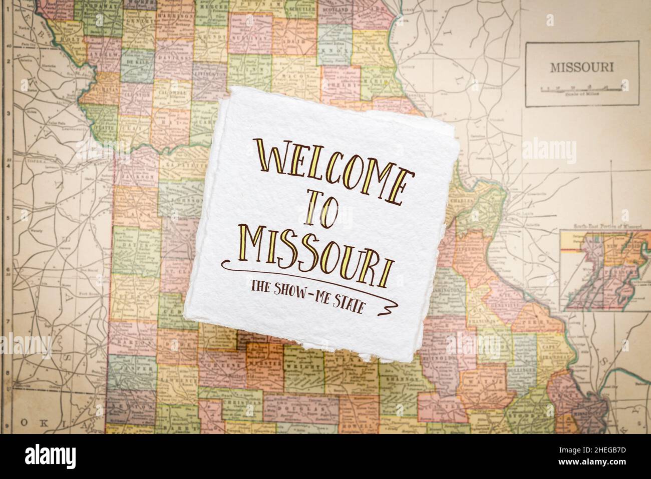 Willkommen in Missouri, dem Show-me-Staat - Handschrift auf einem quadratischen Blatt aus grobem, handgefertigtem Papier, das über einer Vintage-Unschärfe-Karte von Missouri schwebt Stockfoto