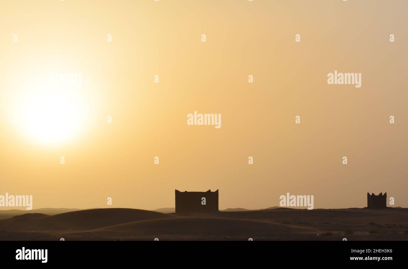 Zwei in einer Mitte einer Wüste stehende Häuser genannt Biwaks. Belichtung bei Sonnenuntergang. Stockfoto