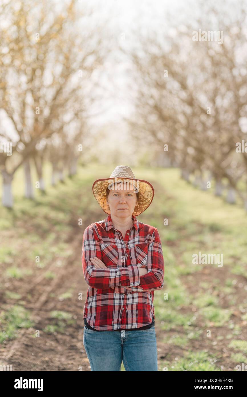 Portrait einer Bäuerin mit gekreuzten Armen in Bio-Walnussplantagen, nachhaltiger Landwirtschaft und hausgemachten Produkten Konzept, selektiver Fokus Stockfoto