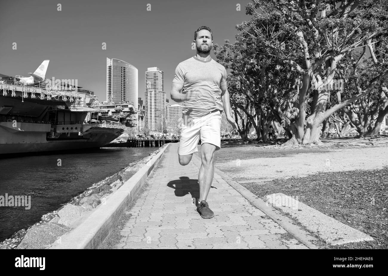 Aktiver Mann Läufer in Sportbekleidung laufen auf Promenade, Laufen Stockfoto