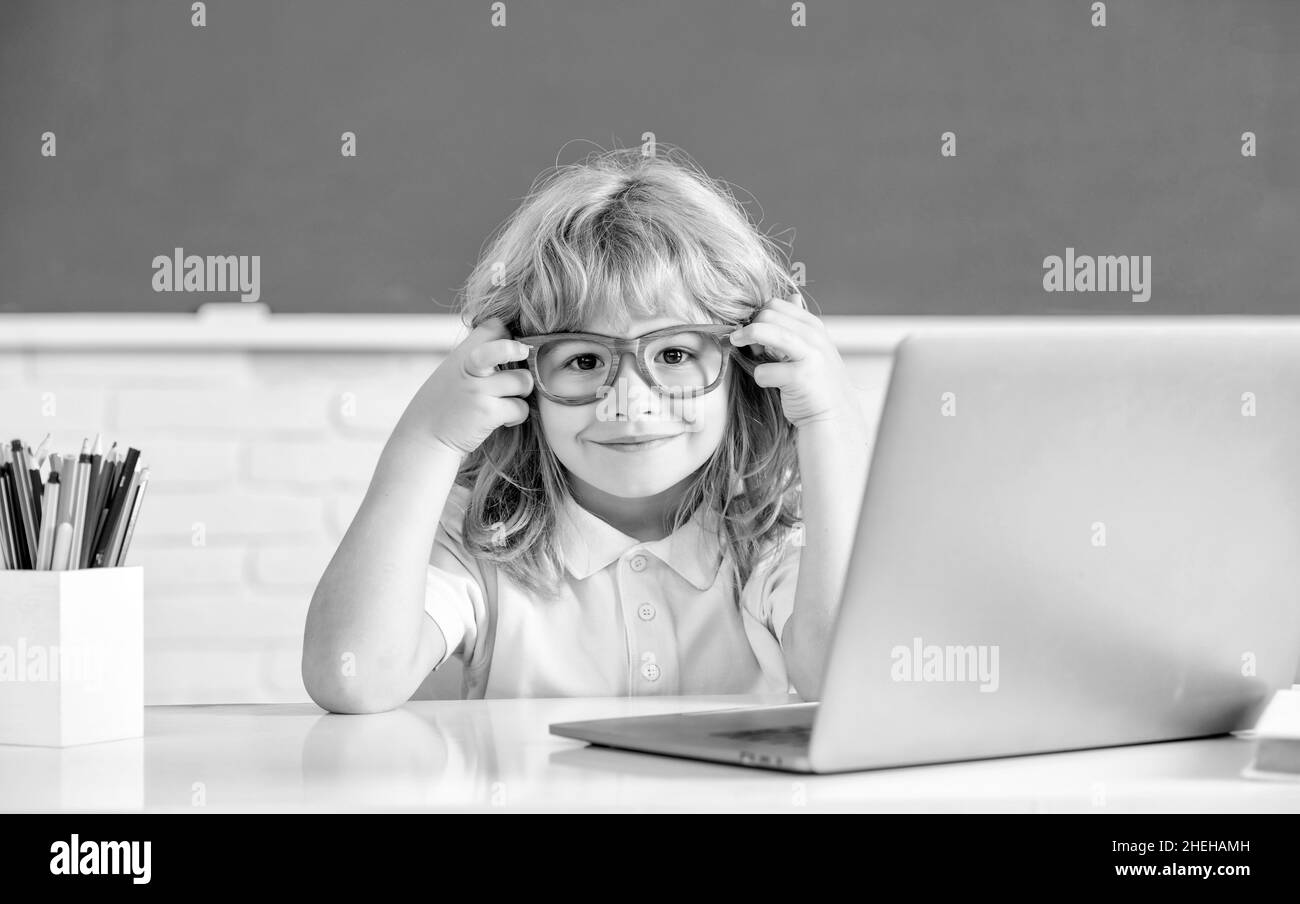 1. september. E-Learning. Kind studiert am Computer. Glücklicher Teenager Junge im Klassenzimmer. Stockfoto