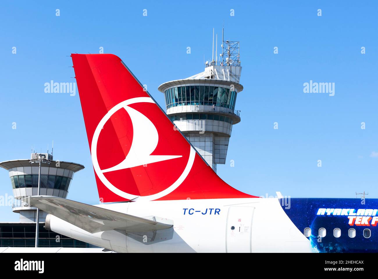 Turkish Airlines Logo auf den Schwänzen eines Airbus A321-Flugzeugs mit einem Flugsicherungsturm im Hintergrund. Stockfoto