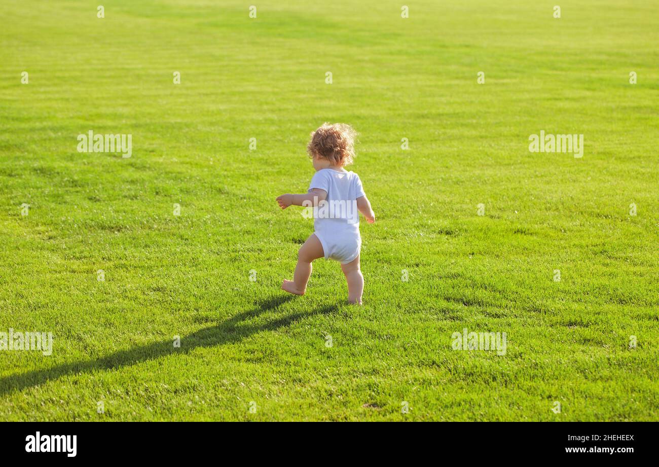 Rückansicht von Baby Wandern im Park in Windelhosen. Gesundes Kind. Stockfoto