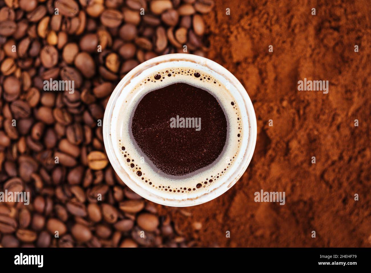 Tasse schwarzen Kaffee in der Mitte des Kaffees gemacht Hintergrund - Hälfte in Getreide Hälfte in Pulver, Draufsicht Bild. Stockfoto