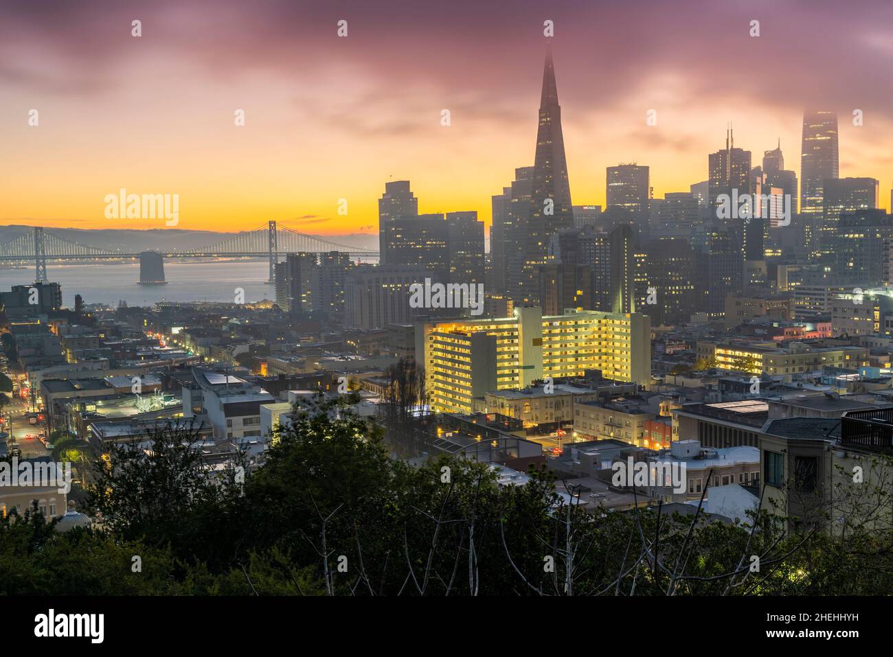 Nebliger Sonnenaufgang über der Innenstadt mit Bay Bridge im Hintergrund, San Francisco, Kalifornien, USA Stockfoto