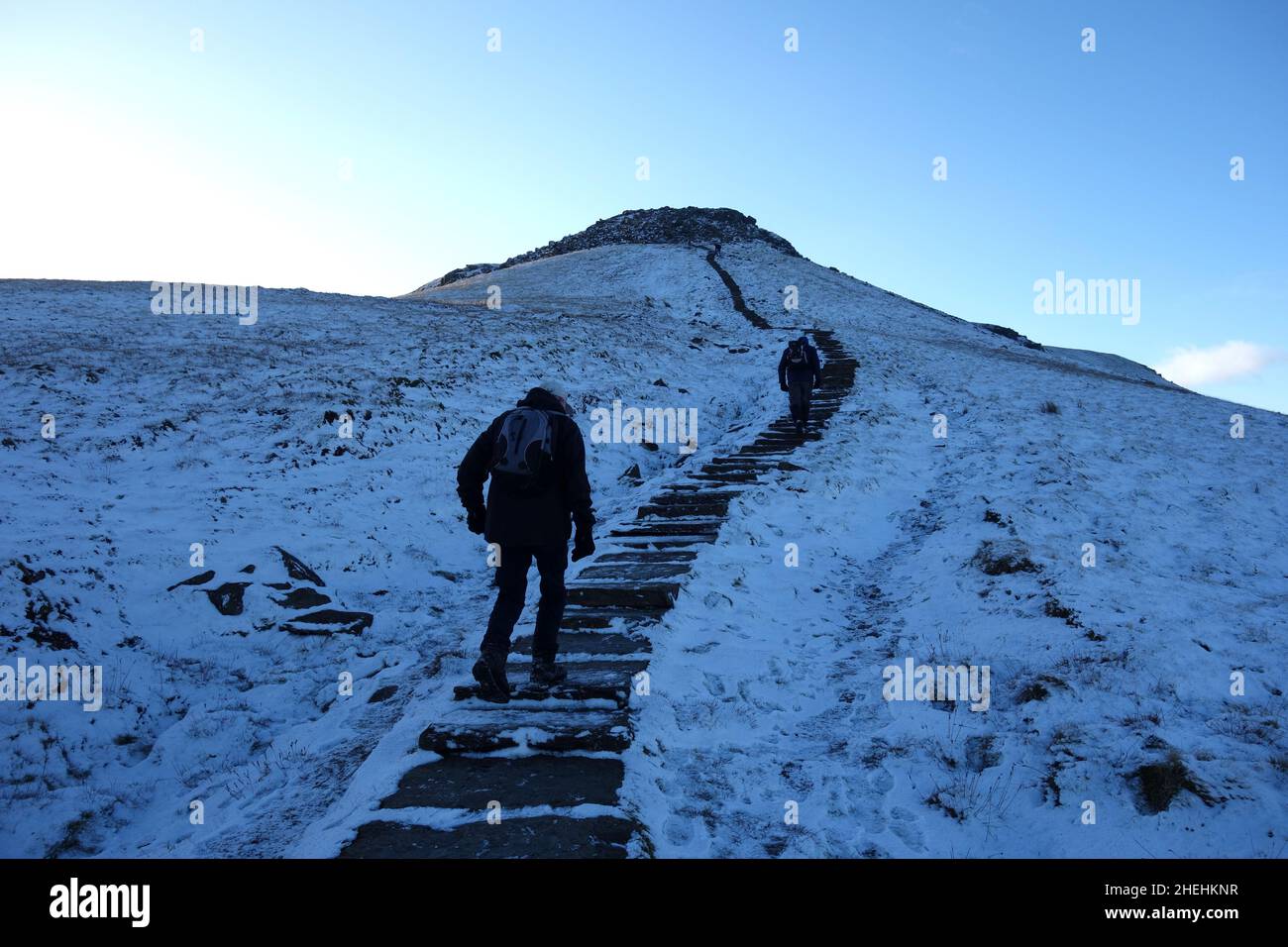 Two Men Walking Icy Stone Steps to the Summit Ingleborough (1 der Yorkshire 3 Peaks) from Chapel-le-Dale, Yorkshire Dales National Park, England. Stockfoto