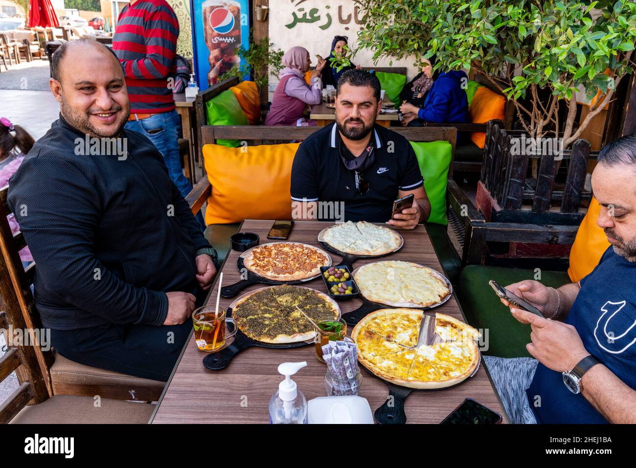 Eine Gruppe jordanischer Männer, die ein traditionelles Frühstück mit Fladenbrot essen, Aqaba, Governorat Aqaba, Jordanien. Stockfoto