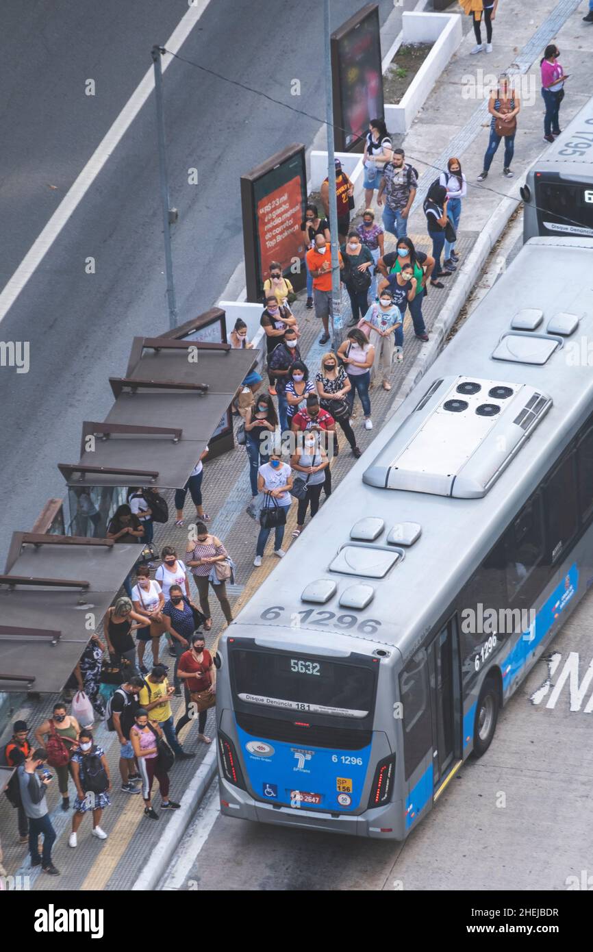 Gelenkbusse auf einer verkehrsreichen Stadtautobahn. BRT (Bus Rapid Transit) Gelenkbus in einer BRT-Busspur. Passagiere an der Bushaltestelle. Sao Paulo, Brasilien Stockfoto