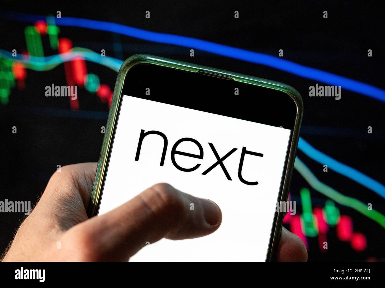 China. 4th Dez 2021. In dieser Abbildung ist das Logo des britischen multinationalen Bekleidungs-, Schuh- und Heimproduktehändlers Next plc zu sehen, das auf einem Smartphone mit einem Index der wirtschaftlichen Börse im Hintergrund angezeigt wird. (Bild: © Budrul Chukrut/SOPA Images via ZUMA Press Wire) Stockfoto
