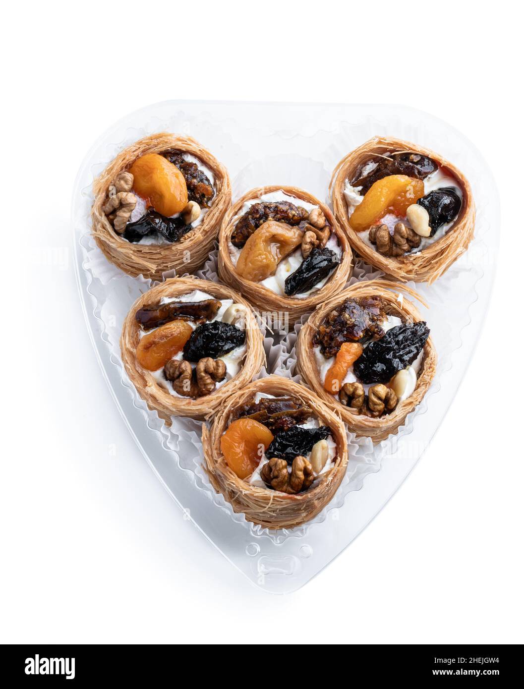 Traditionelle arabische und türkische Süßigkeiten Gebäck Dessert Kadaif mit Nüssen und getrockneten gesüßten Früchten isoliert auf weiß Stockfoto