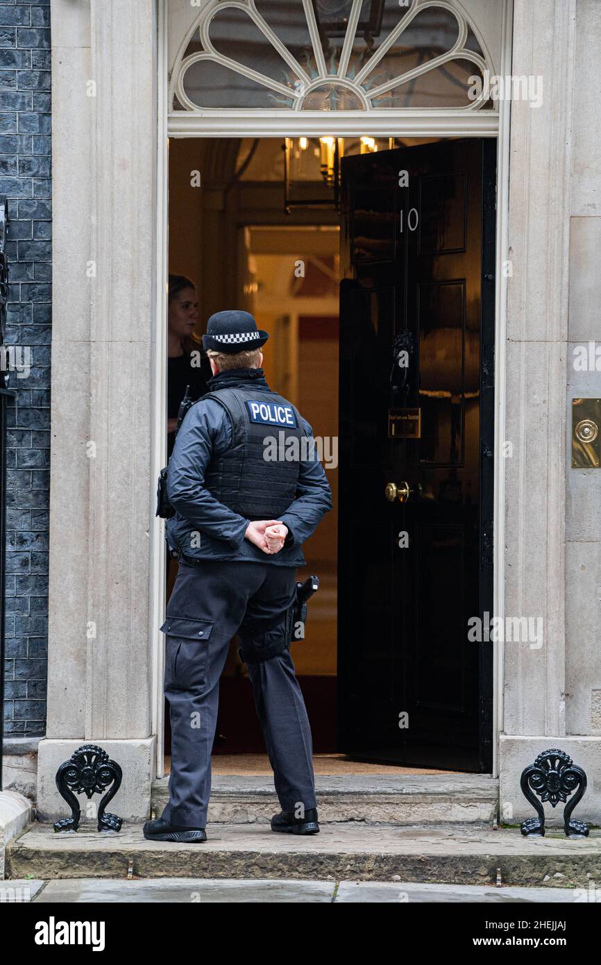 WESTMINSTER, LONDON, GROSSBRITANNIEN. 11. Januar 2022. Ein Polizeibeamter vor der Tür der Downing Street 10. Premierminister Boris Johnson Gerät unter Druck, als die Polizei erwäge, eine Untersuchung über eine Sperrpartei durchzuführen, die am 20. Mai 2020 stattfand, als angeblich der private Sekretär der Downing Street, Martin Reynolds, mehr als 100 Regierungsangestellte dazu eingeladen hatte, in einem Garten „eigenen Alkohol mitzubringen“ Party .Credit: amer ghazzal/Alamy Live News Stockfoto