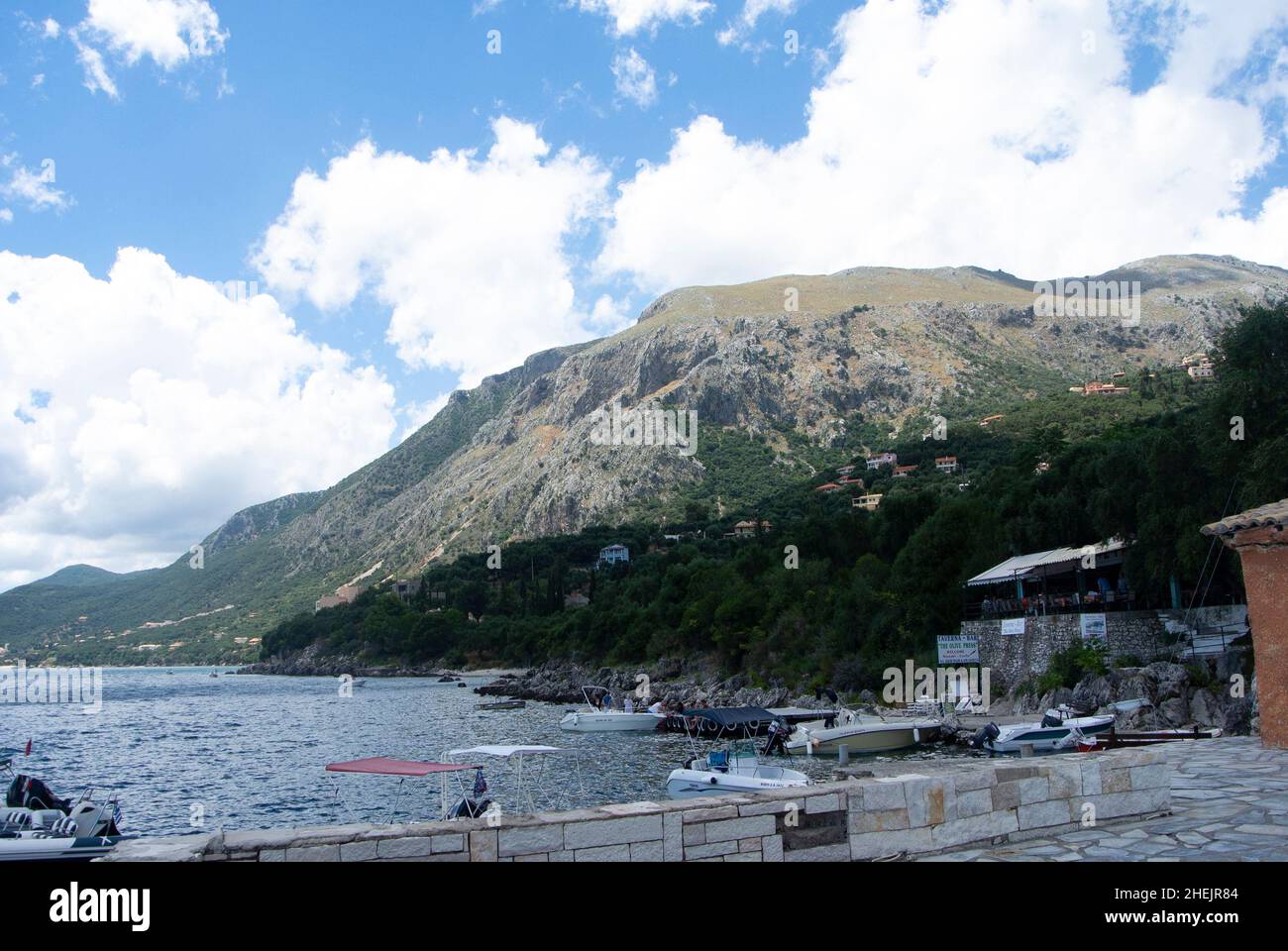 Nissaki Village, Korfu - Griechenland - Juli 10 2014 : wunderschöne Küstenlandschaft mit dramatischen hohen Klippen und Bergen. Kleines griechisches Inselferienresor Stockfoto