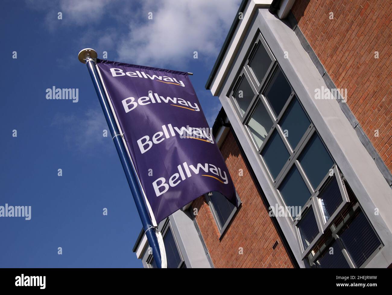 Bellway Häuser Flaggenschild vor neu gebauten Häusern Häuser Eigentum, blauer Himmel. Stockfoto