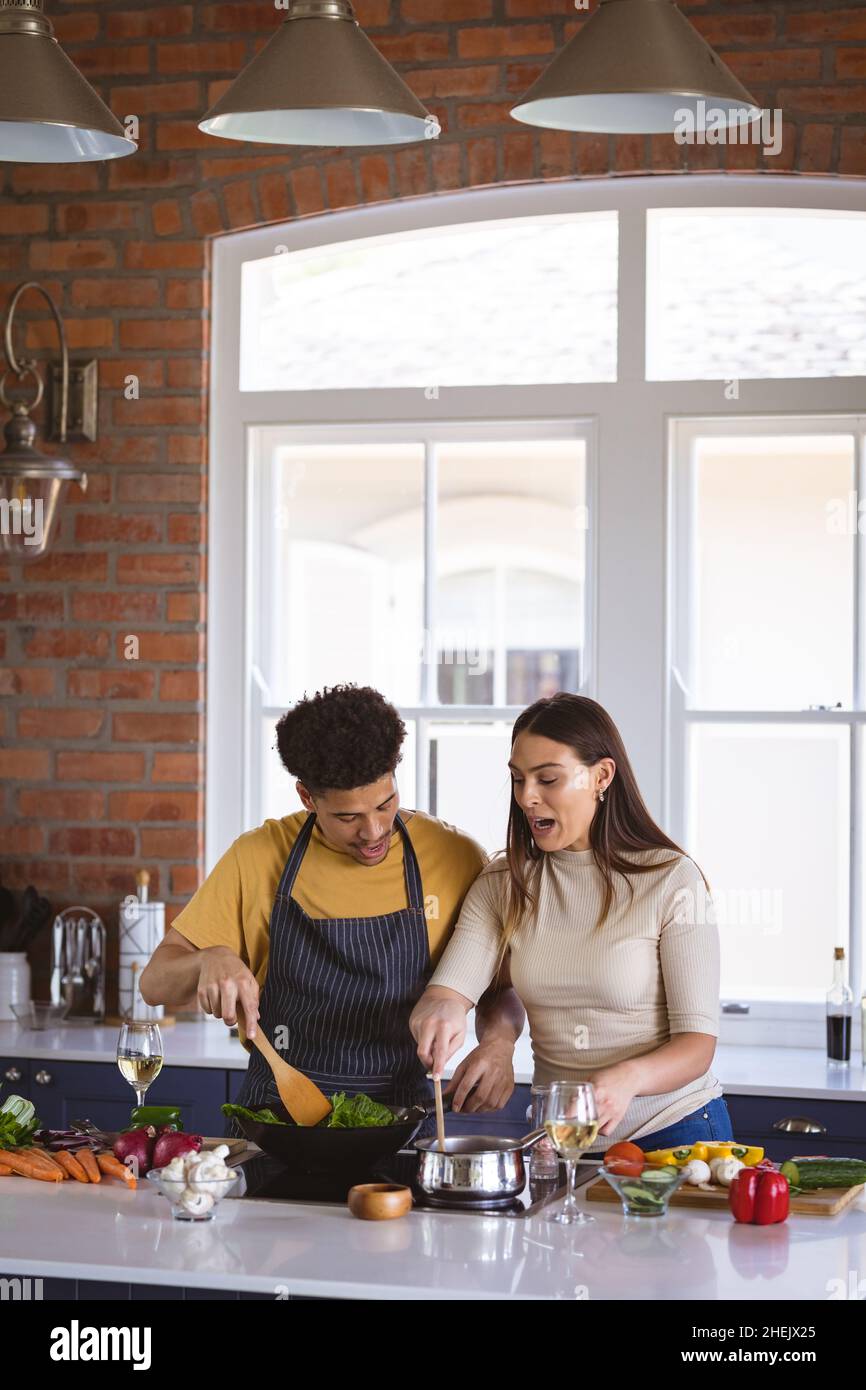 Junge Biracial Freund und Freundin Kochen Essen zusammen in der Küche zu Hause Stockfoto