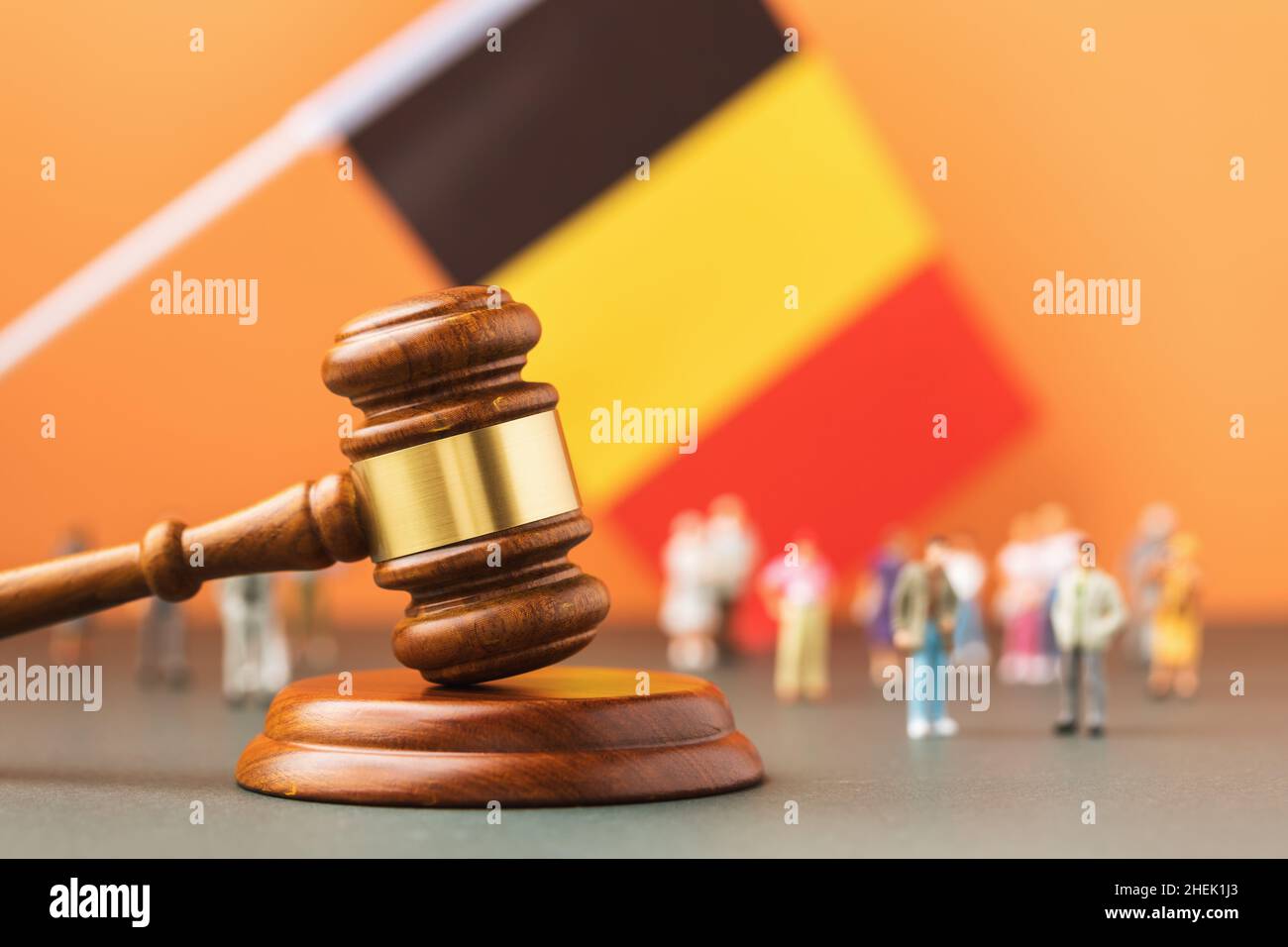 Hölzerne Richter gavel, Flagge und Kunststoff-Spielzeug auf einem farbigen Hintergrund, das Konzept des Rechtsstreits in der belgischen Gesellschaft Stockfoto