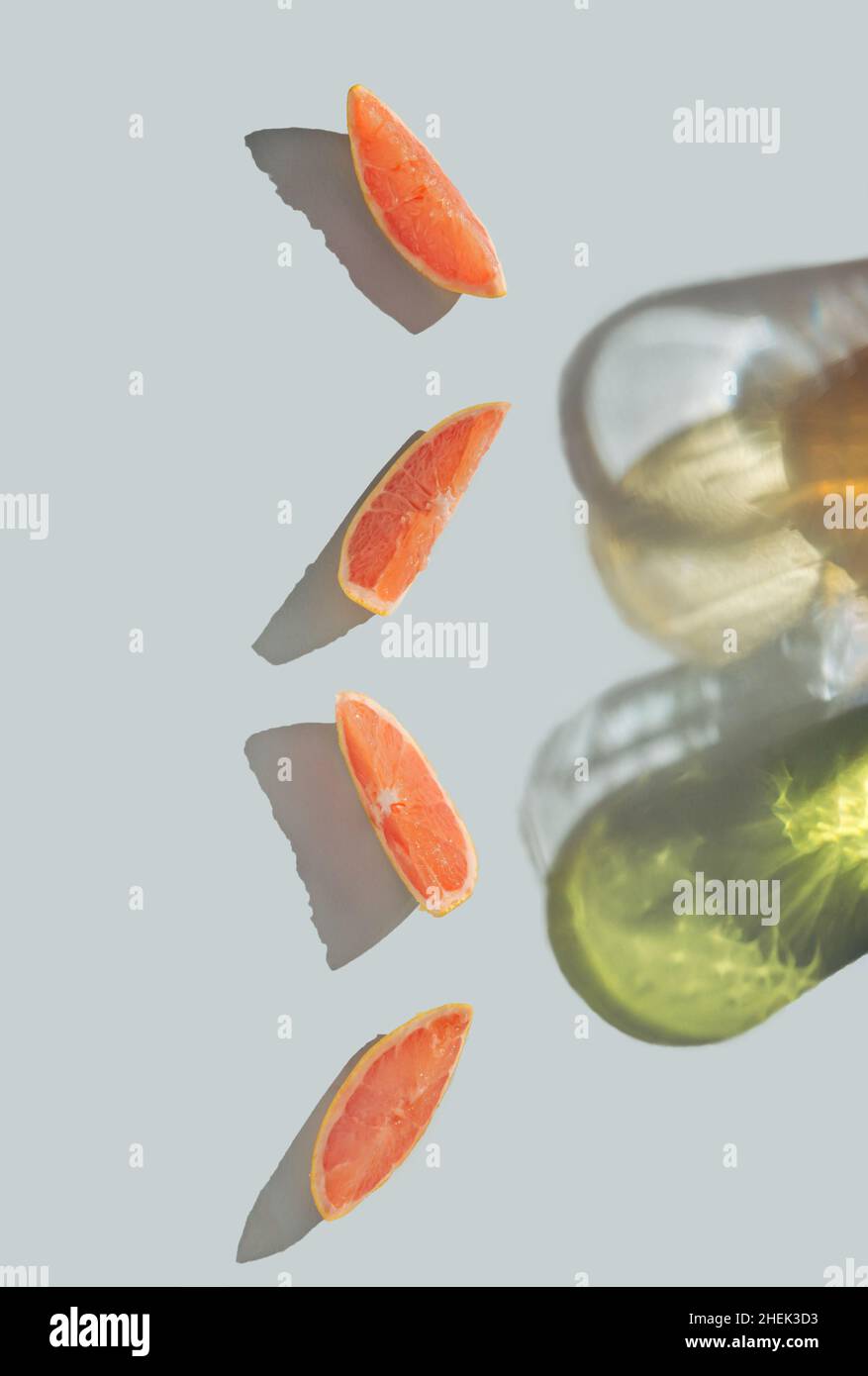 Kreatives Layout aus Grapefruit-Scheiben und farbenfrohen, trendigen Schatten. Harte Sonneneinstrahlung auf pastellfarbenem Hintergrund. Stockfoto