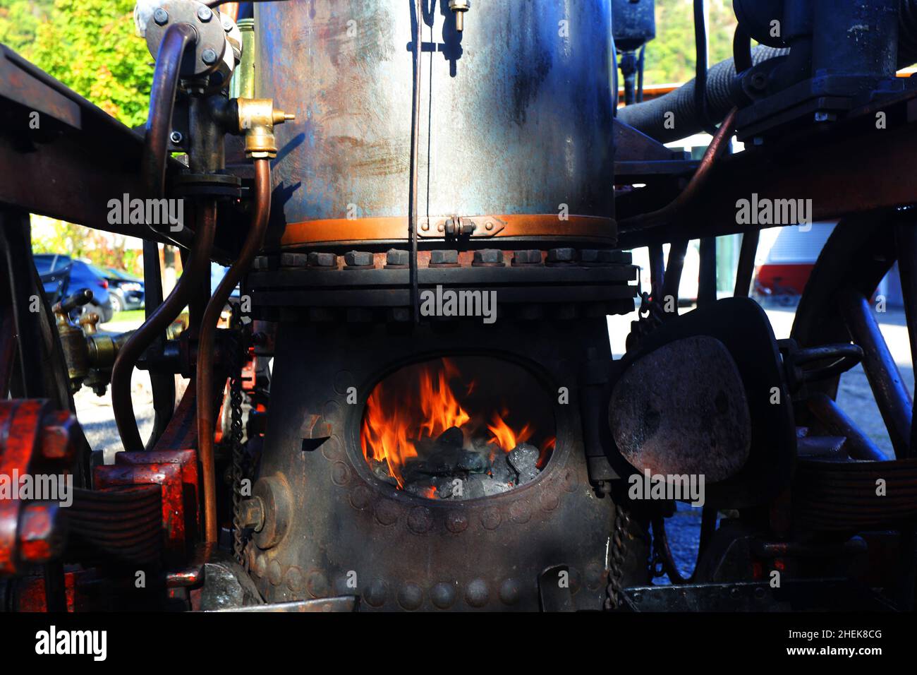 Alter Dampfkessel mit Feuer und Rauch wird geheizt, Historische Technik und Industrie Stockfoto