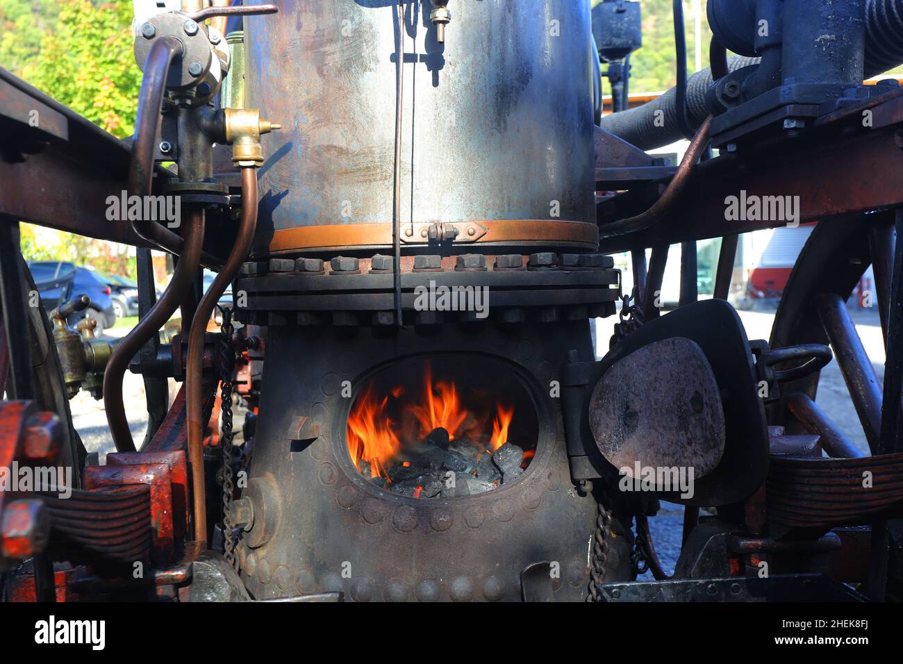 Alter Dampfkessel mit Feuer und Rauch wird geheizt, Historische Technik und Industrie Stockfoto