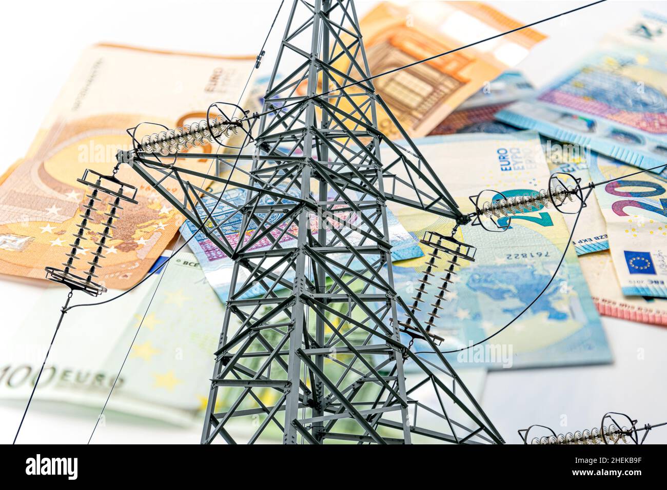 Elektrischer Turm und Euro-Geld, Hochspannungsmast auf Euro-Banknoten im selektiven Fokus, Energiekostenkonzept Stockfoto