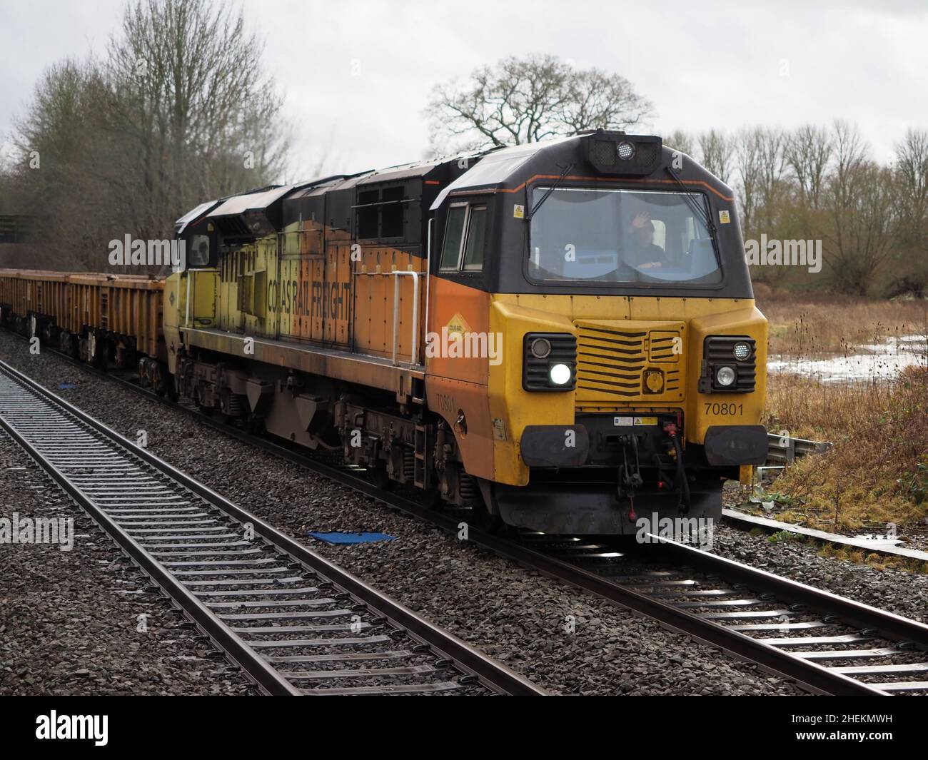 Colas Rail Class 70 70801 mit Zug von Ballastwagen am Bahnhof Kings Sutton, Northamptonshire Stockfoto