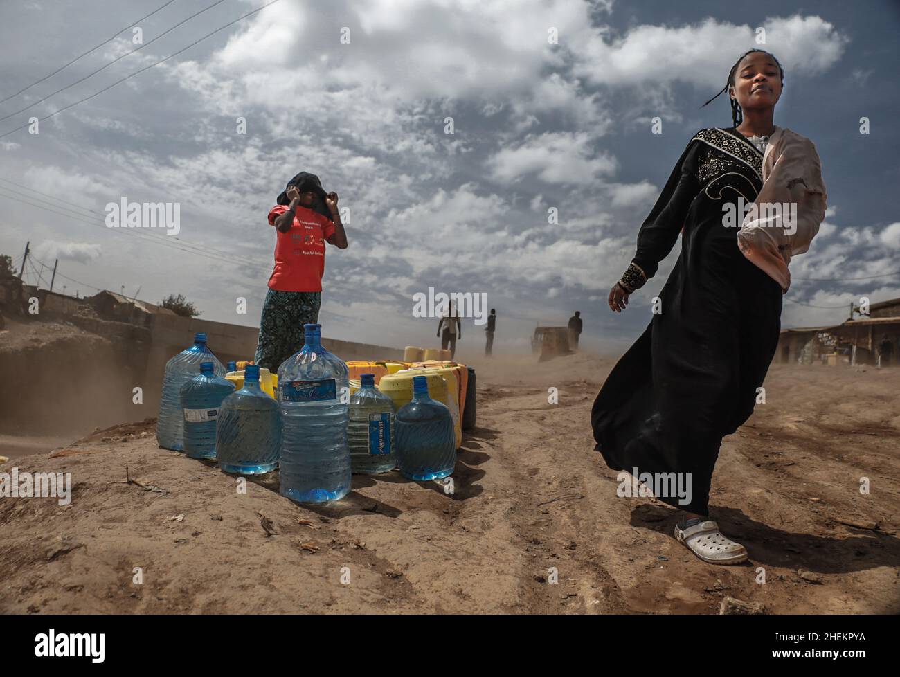 Nairobi, Kenia. 11th Januar 2022. Eine Frau sah, wie sie während des Wassermangels an Wasserkanern vorbeiging.die meisten Einwohner von Nairobi erleben weiterhin den täglichen Mangel und Mangel an Wasser. In den Slums von Kibera haben die Nairobi Metropolitan Services (N.M.S) die Verantwortung übernommen, den meisten Bewohnern in einigen armen Gemeinden den Zugang zu kostenlosen und häufigen Trinkwasserdiensten zu ermöglichen. Kredit: SOPA Images Limited/Alamy Live Nachrichten Stockfoto