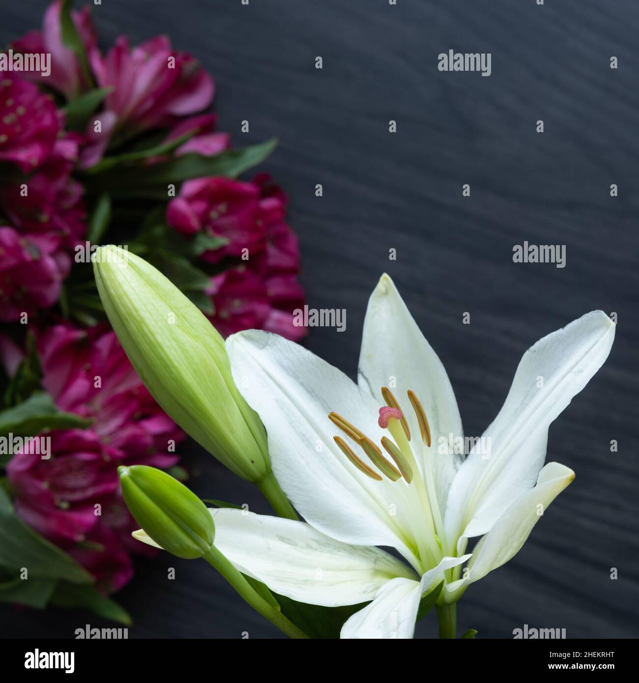 Frische Lilie und rosa Alstroemeria Blumenstrauß auf einem dunklen Holzhintergrund mit Kopierraum Stockfoto