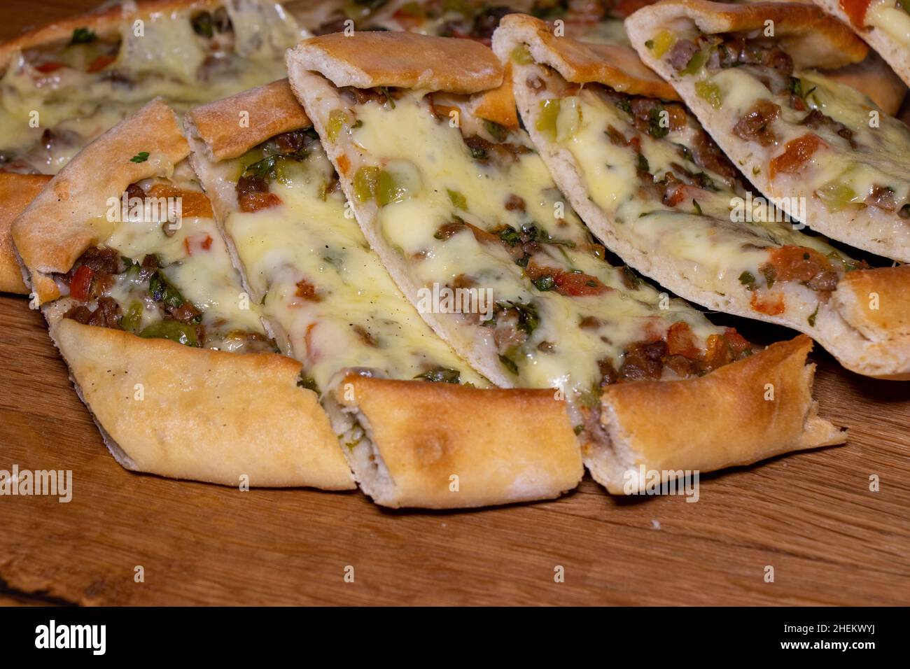 Türkische Pita mit Rindfleisch und Käse. Türkisches Pide mit Fleischkäse und Gemüse auf einem hölzernen Hintergrund Stockfoto