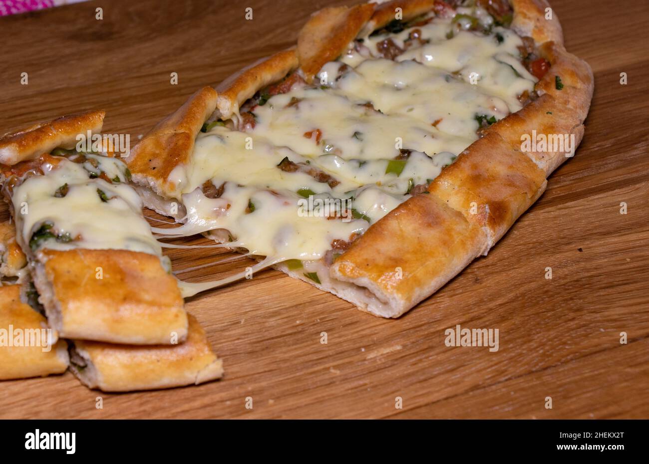 Türkische Pita mit Rindfleisch und Käse. Türkisches Pide mit Fleischkäse und Gemüse auf einem hölzernen Hintergrund Stockfoto