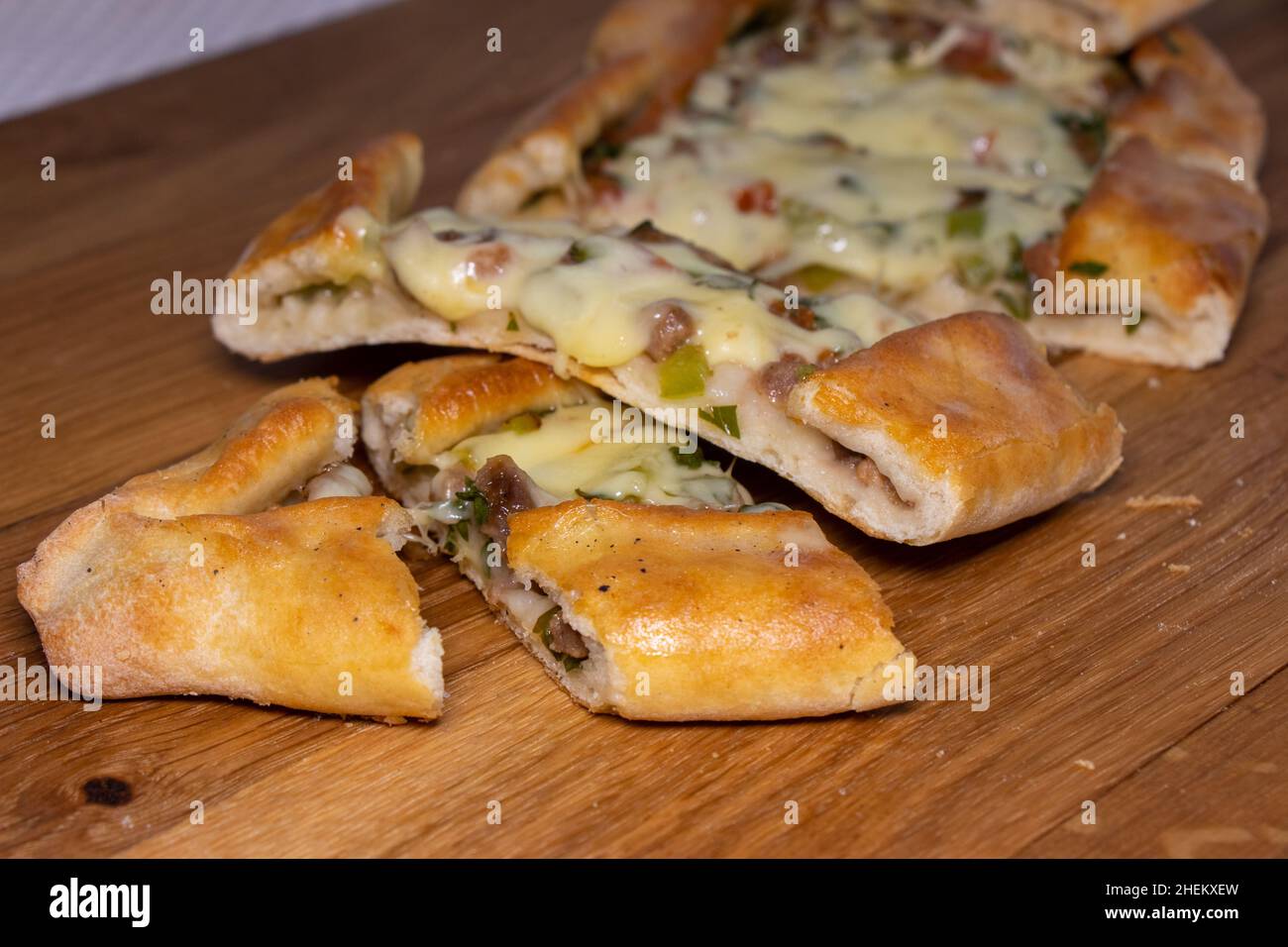 Türkische Pita mit Rindfleisch und Käse. Türkisches Pide mit Fleischkäse und Gemüse auf einem hölzernen Hintergrund Stockfoto