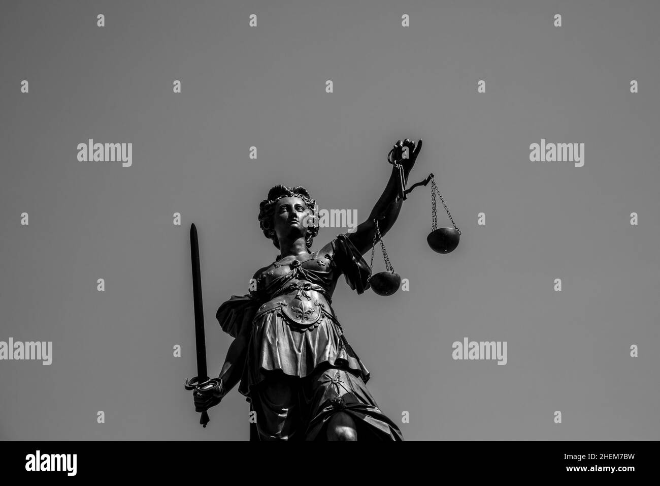 Lady Justice im Römer in Frankfurt am Main symbolisiert Gerechtigkeit mit Schwert und Schuppen unter blauem Himmel. Stockfoto