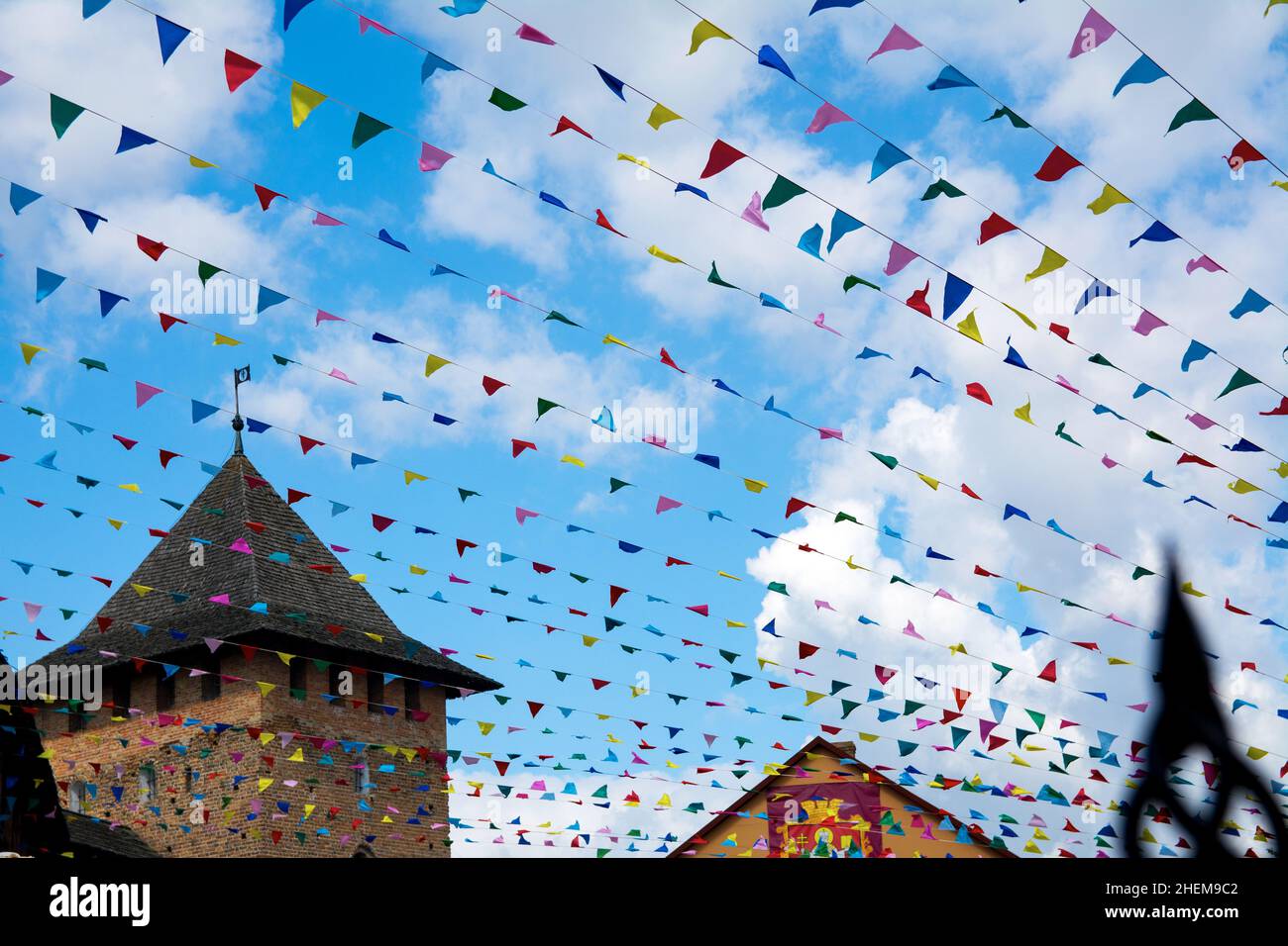 Party bunte Fahnen und Schloss auf dem Rücken vor blauem Himmel Hintergrund. Dekoration für Feiertage-Flaggen. Stockfoto