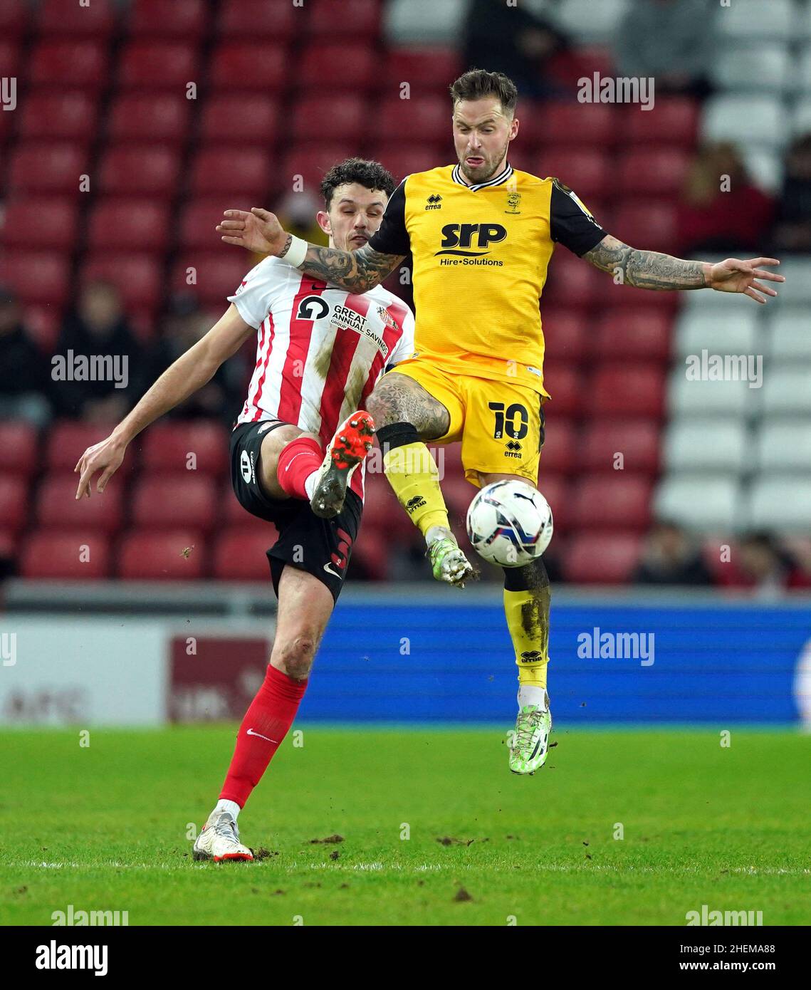 Tom Flanagan von Sunderland und Chris Maguire von Lincoln City (rechts) kämpfen während des Sky Bet League One-Spiels im Stadium of Light, Sunderland, um den Ball. Bilddatum: Dienstag, 11. Januar 2022. Stockfoto