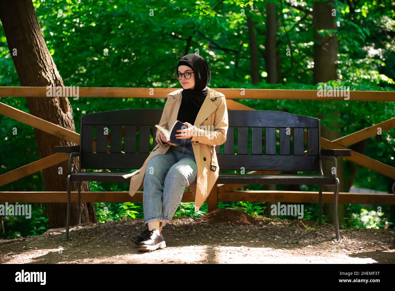 Muslimische Frau, die während ihrer Freizeit im Park ein Buch liest. Stockfoto