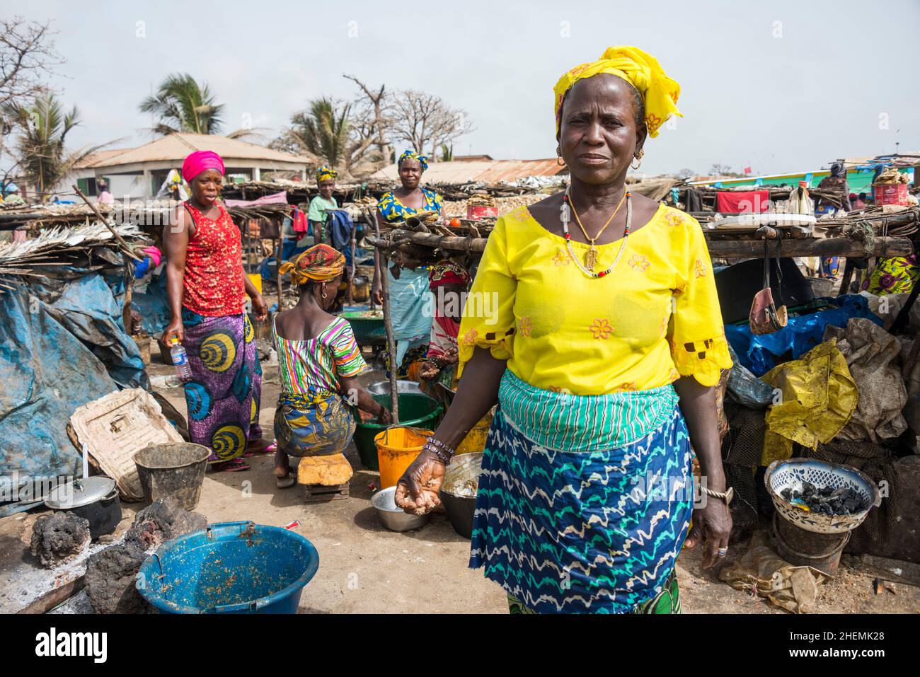 Frauen, die in der Nähe des Strandes an der Tanji-Küste in Gambia Fisch rauchen Stockfoto