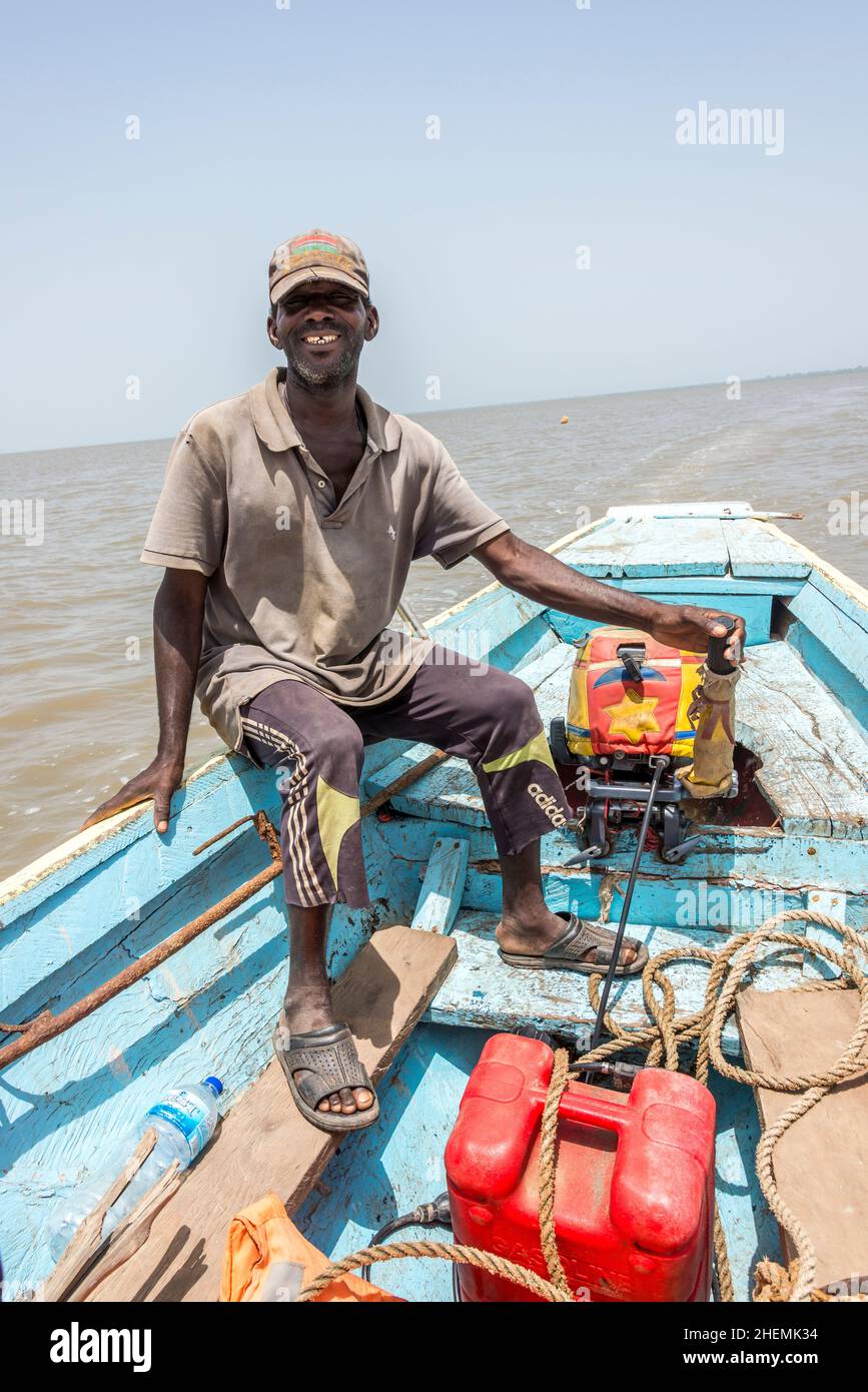 Mann segelt in einem Außenbordmotorkanu auf dem Gambia River in der Nähe von James Island Stockfoto